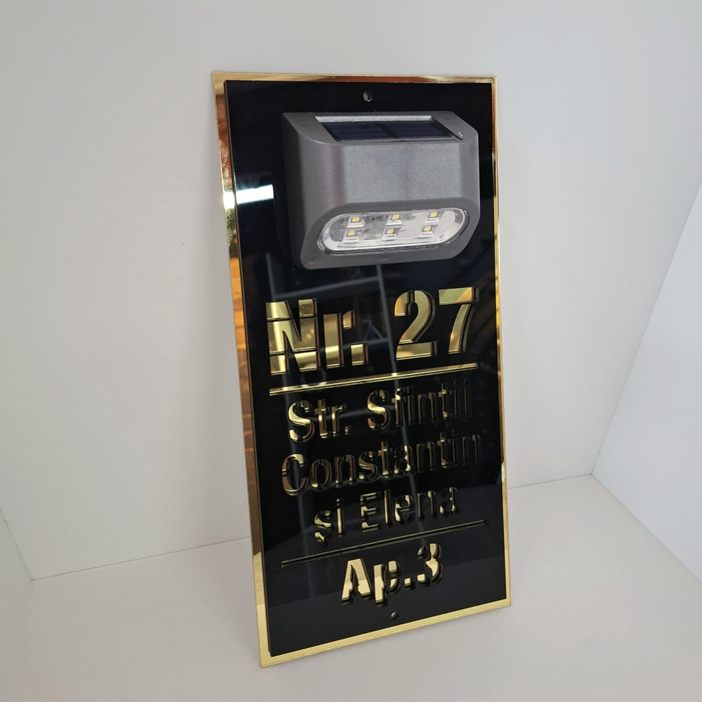 Plăcuță adresă casă cu lumină solară, realizată din plexiglas negru și auriu cu text decupat laser. [1]