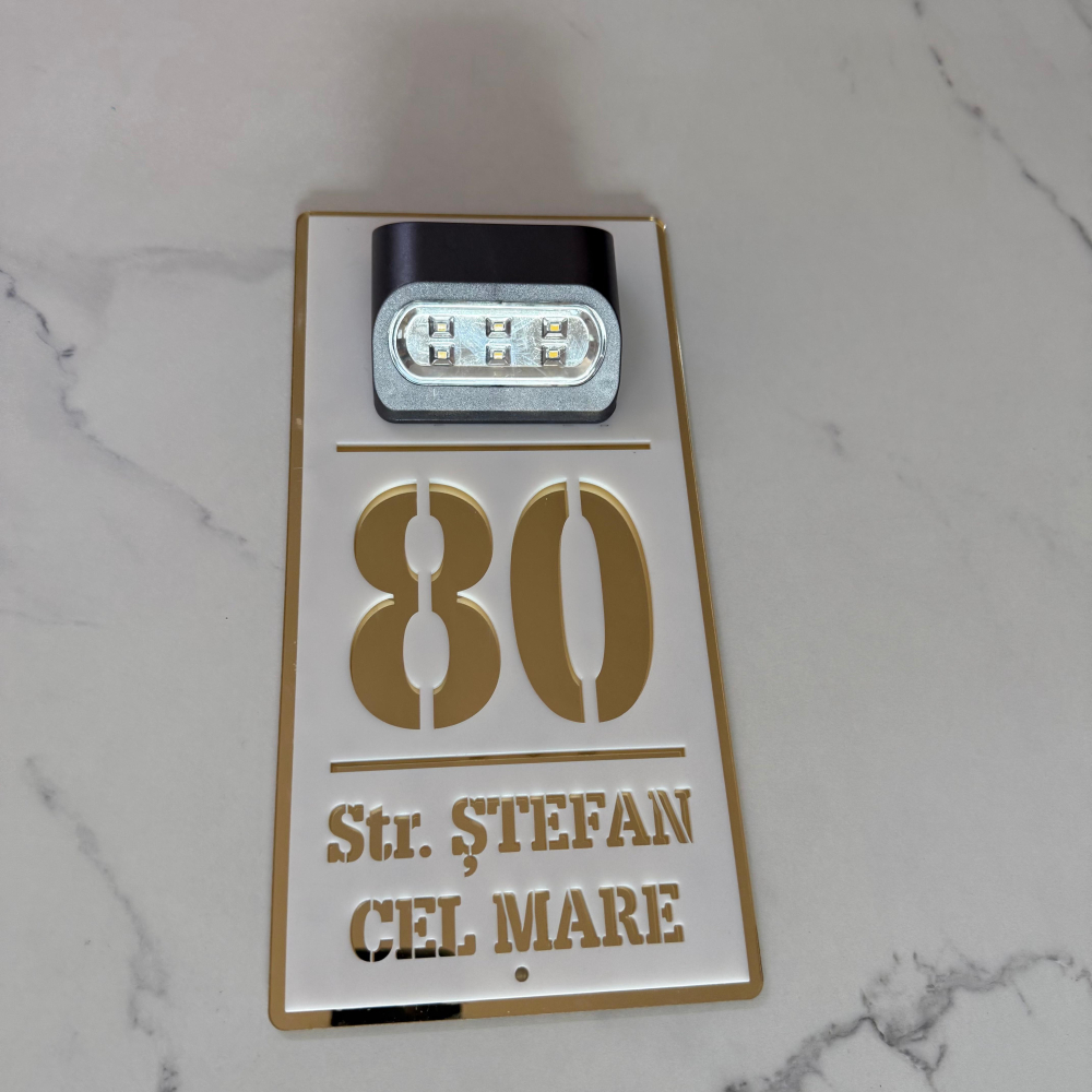 Plăcuță adresă casă albă cu detalii aurii și lumină solară – număr stradal personalizat, vizibil pe timp de noapte. [4]