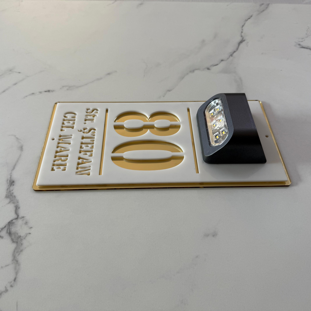 Plăcuță adresă casă albă cu detalii aurii și lumină solară – număr stradal personalizat, vizibil pe timp de noapte. [3]