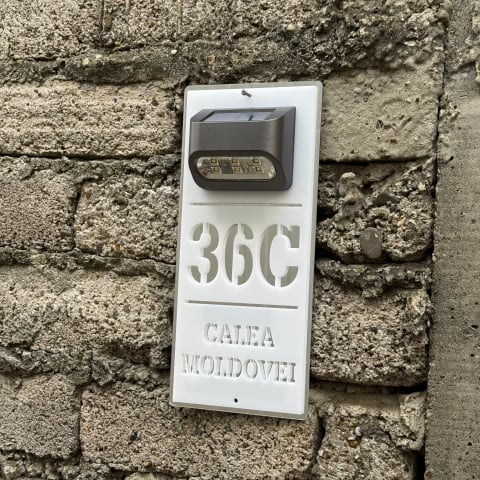 Plăcuțe casă personalizate - Plăcuță adresă casă albă cu detalii argintii și lumină solară – număr stradal personalizat, vizibil pe timp de noapte.